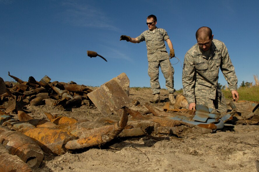 Explosive ordnance disposal technicians Staff Sgt. Kenneth Schnorbus, left, and Staff Sgt. Michael Newton separate bomb dummy units from scrap metal during a range clearance at Poinsett Electronic Combat Range near Shaw AFB, S.C., April 17, 2009.  Shaw F-16 aircraft pilots drop bomb dummy units on the range for target practice. (U.S. Air Force photo by Senior Airman Kathrine McDowell/Released)