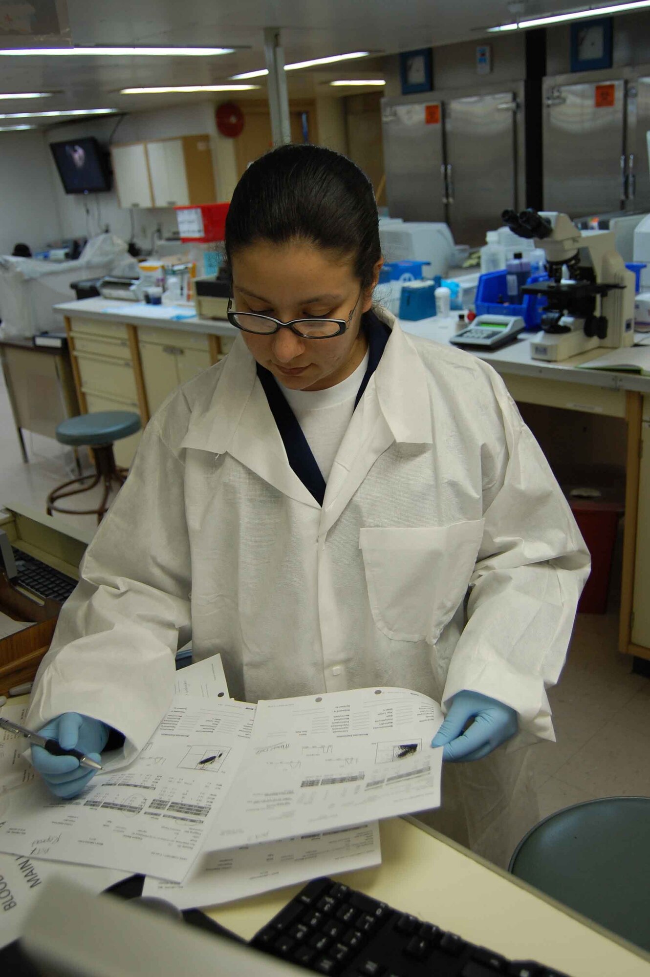 USNS COMFORT - Hospital Corpsman 2nd Class Liliana Dominguez, a laboratory technician aboard the hospital ship USNS Comfort, annotates a patient's test results April 13. 