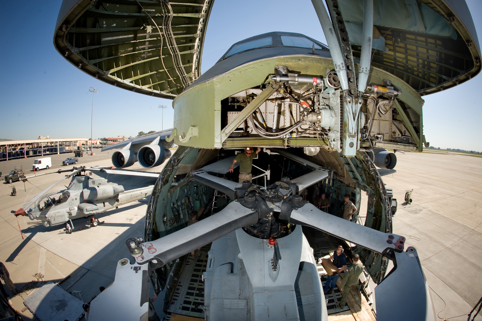 Marine Sgt. Destin Waldron is the top side spotter on a UH-1Y helicopter being maneuvered into a C-5C Galaxy.  Airmen from Travis Air Force Base, Calif., and Marines from Camp Pendleton, Calif., came together at Travis AFB April 20 to determine how the helicopter best fit into the cargo bay of the C-5 and how many could be loaded at one time.  The goal is to get helicopters into the area of responsibility faster and ultimately into the fight.  Sergeant Waldron is a crew chief with Marine Light Attack Helicopter Squadron 367 at Camp Pendleton.  (U.S. Air Force photo/Lance Cheung)