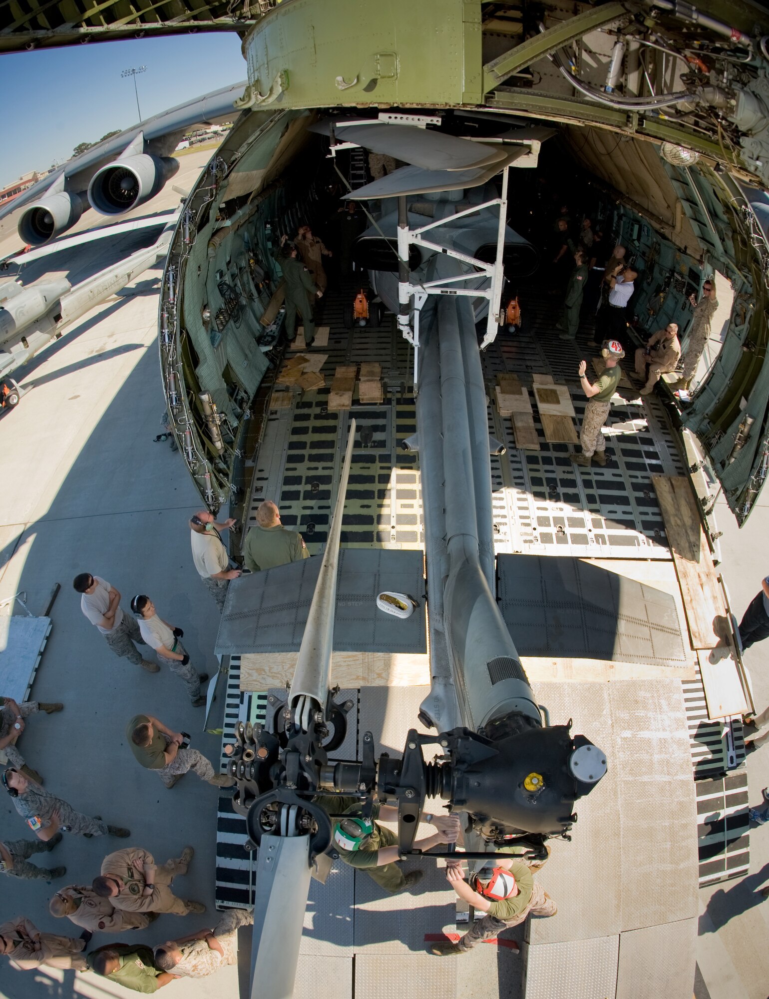 A Marine AH-1Z Super Cobra attack helicopter is maneuvered into a C-5C Galaxy.  Airmen from Travis Air Force Base, Calif., and Marines from Camp Pendleton, Calif., came together at Travis AFB April 20 to determine how the helicopter best fit into the cargo bay of the C-5 and how many could be loaded at one time.  The goal is to get helicopters into the area of responsibility faster and ultimately into the fight.  (U.S. Air Force photo/Lance Cheung)