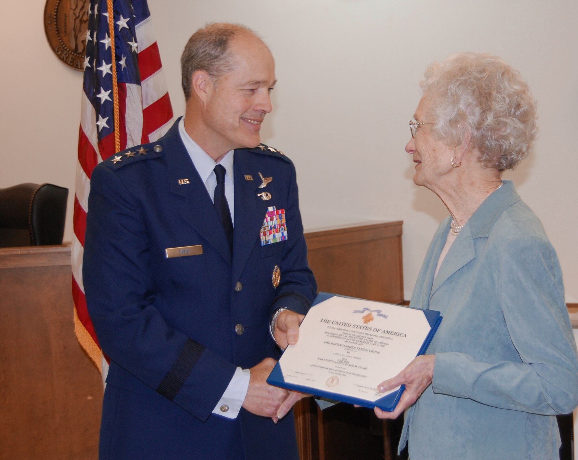 Lt. Gen. Allen Peck, Air University commander, presents Mrs. Doris Norred with her late husband's Distinguished Flying Cross with Valor April 13. Capt. William Norred's military records were reviewed, and it was determined he earned the DFC on a combat mission during World War II. (U.S. Air Force photo/Carl Bergquist)