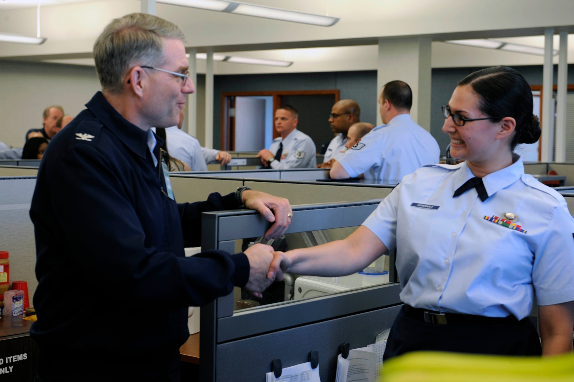 (Left) Col. Joseph S. Ward Jr., Air Force Material Command Financial Management  director, shakes hands with Airman 1st Class Lauren Hernandez, Air Force Material Command military pay technician, here, April 20. Colonel Ward visited each section in the Air Force Financial Services Center to get a better understanding of how the center completes its mission. (U.S. Air Force photo by Airman First Class Corey Hook)