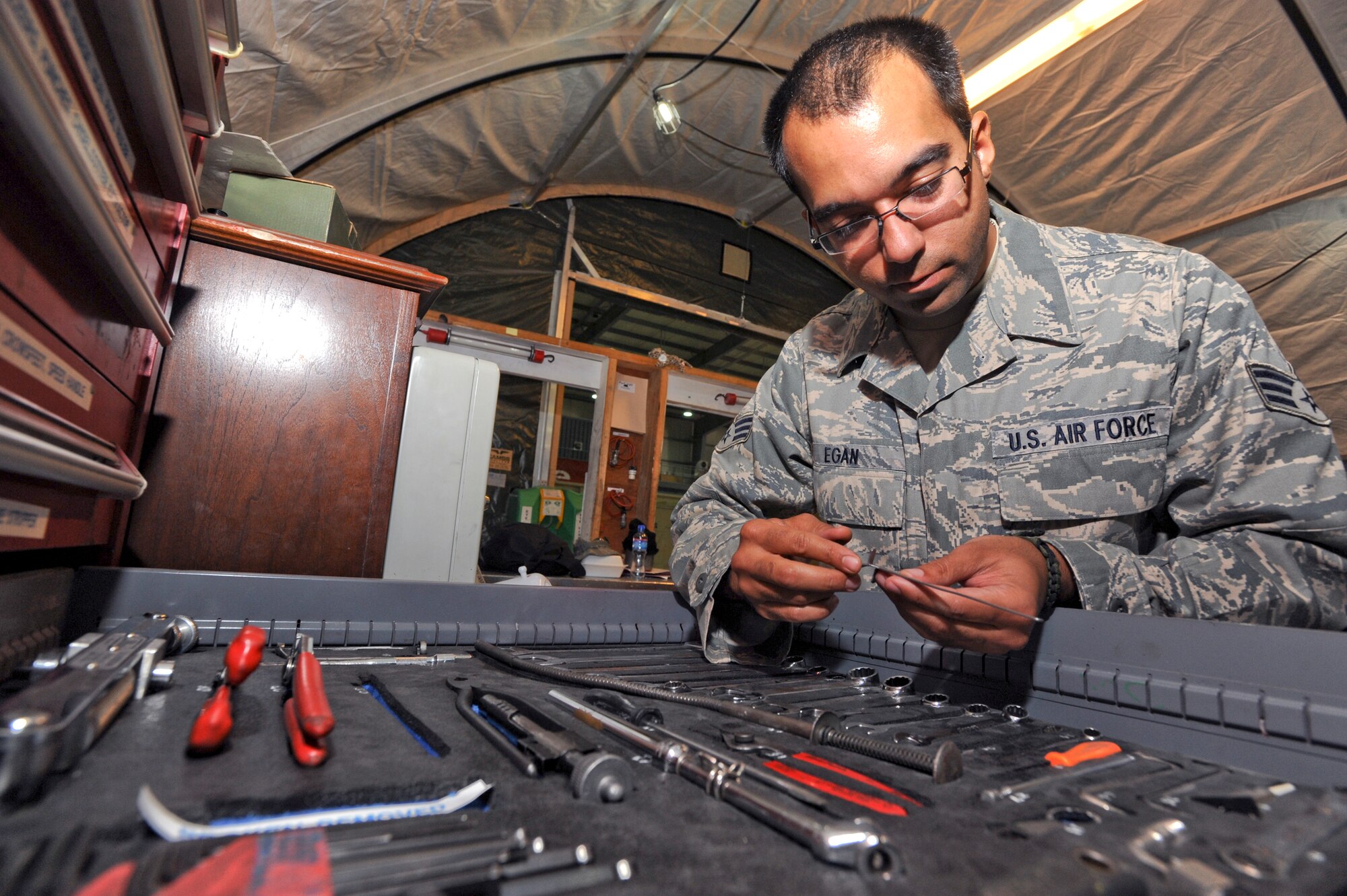 Senior Airman Fred Egan, an avionics technician with the 746th Aircraft Maintenance Unit, performs a daily tool inventory inspection, April 20, 2009, in an undisclosed location in Southwest Asia.  All tools are inspected within the tool shed prior to a shift change to ensure all items are accounted for.  Airman Egan hails from North Vernon, Ind. and is deployed from Youngstown Air Reserve Station, Ohio in support of Operations Iraqi and Enduring Freedom and Combined Joint Task Force - Horn of Africa.  (U.S. Air Force Photo by Staff Sgt. Joshua Garcia/released)