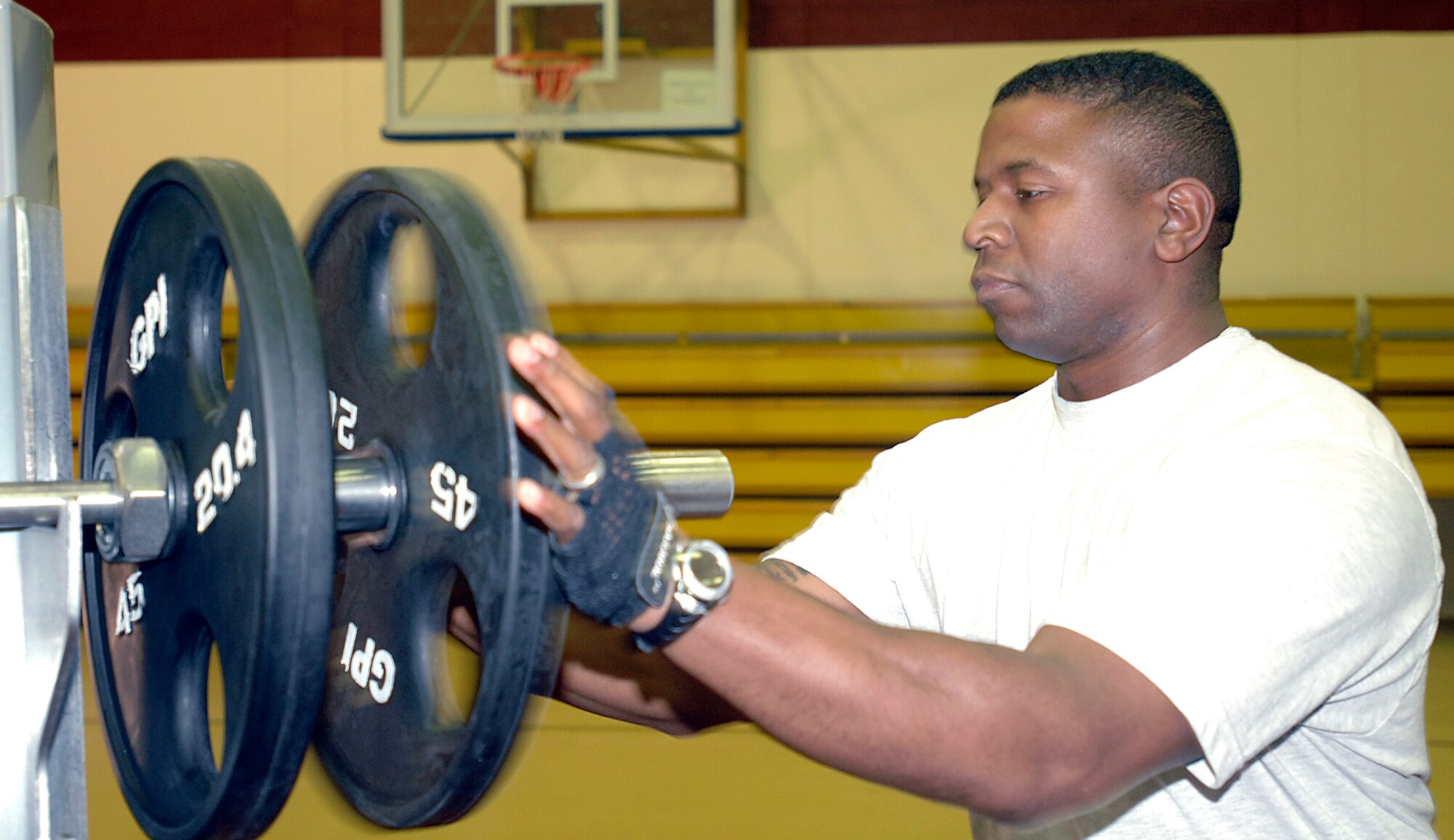 Staff Sgt. Russell Gray, 39th Force Support Squadron, loads a 45 lbs. onto a weight bar during the 39th Force Support Squadron’s first power-lifting competition at the Incirlik Fitness center, April 18, 2009. Competitors lifted the maximum weight they could in squats, dead lift and bench press to achieve a score using the Glossbrenner system. The Glossbrenner Scale multiplies the total weight lifted by a body weight coefficient to even the playing field between all contestants. Staff Sgt. Shaun Crum, 39th Communications Squadron, was awarded 1st place with a total weight of 1,285 lbs. and a score of 792.138. (U.S. Air Force photo/Senior Airman Benjamin Wilson)
