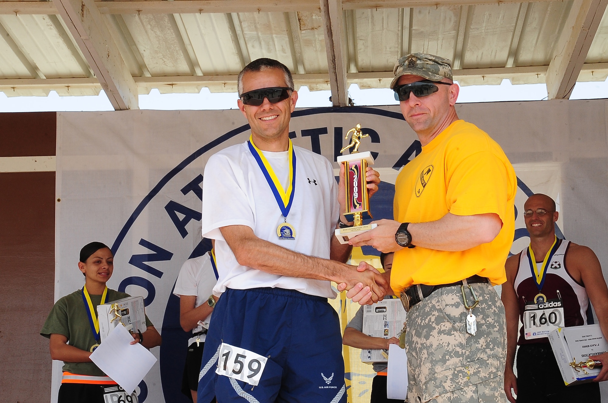 ALI BASE, Iraq – Maj. Harland Peelle, a Defense Contract Management Agency team lead deployed to Forward Operating Base Delta, Iraq, from the Pentagon receives his trophy for finishing the Boston Marathon held at Contingency Operating Base Adder April 18, with a final time of 2 hours, 54 minutes and 31 seconds.  This is the fifth year the marathon has been run at COB Adder. Service members with qualifying times this year will be able to run in Boston at next year’s race.  (U.S. Air Force photo/Staff Sgt. Christopher Marasky)