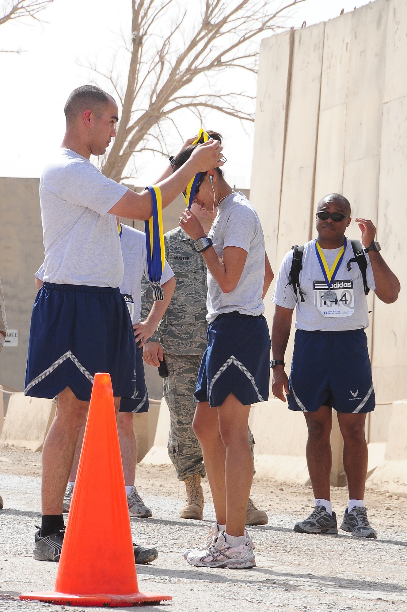 ALI BASE, Iraq – Airmen from the 407th Expeditionary Force Support Squadron give out medals to runners who finished the Boston Marathon held at Contingency Operating Base Adder April 18.  This is the fifth year the marathon has been run at COB Adder. Service members with qualifying times this year will be able to run in Boston at next year’s race.  (U.S. Air Force photo/Staff Sgt. Christopher Marasky)