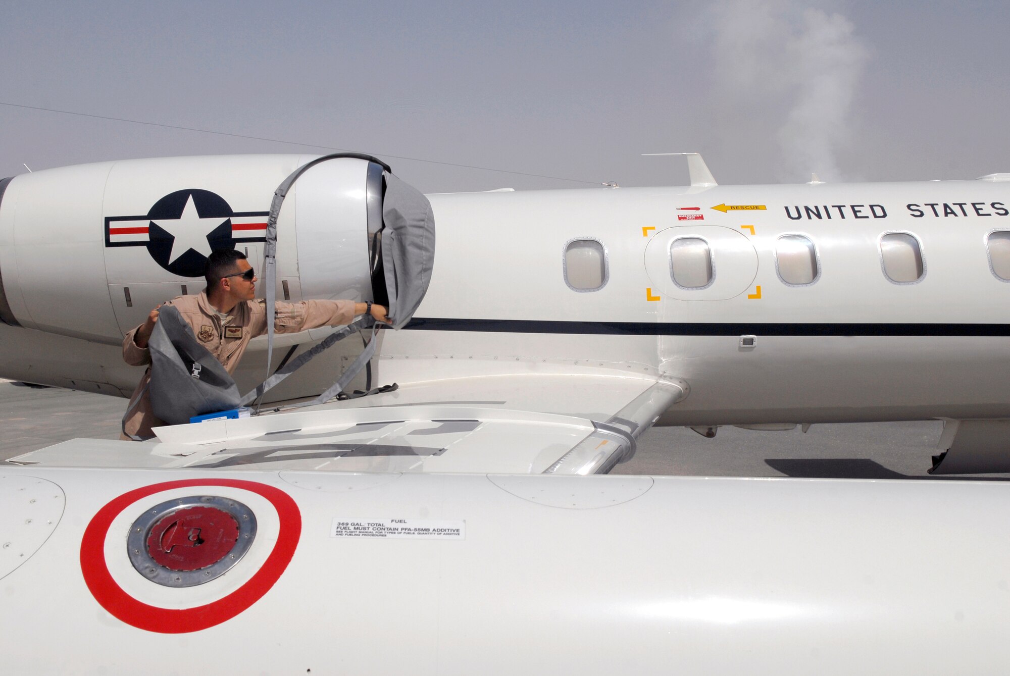 1st Lt. Luis Garces, 379th Expeditionary Operations Group C-21 Pilot, removes an engine cover during a routine pre-flight inspection on a USAF C-21 aircraft, Apr. 15, 2009, at an undisclosed location in Southwest Asia.  The C-21 is an operational support airlift aircraft for transporting personnel and provides emergency medical evacuation transport if needed within the U.S. Central Command's Area of Responsibility.  Lt. Garces hails from Queens, N.Y. and is deployed from Scott Air Force Base, Ill. in support of Operations Iraqi and Enduring Freedom and Combined Joint Task Force - Horn of Africa.  (U.S. Air Force photo/Senior Airman Andrew Satran/released)