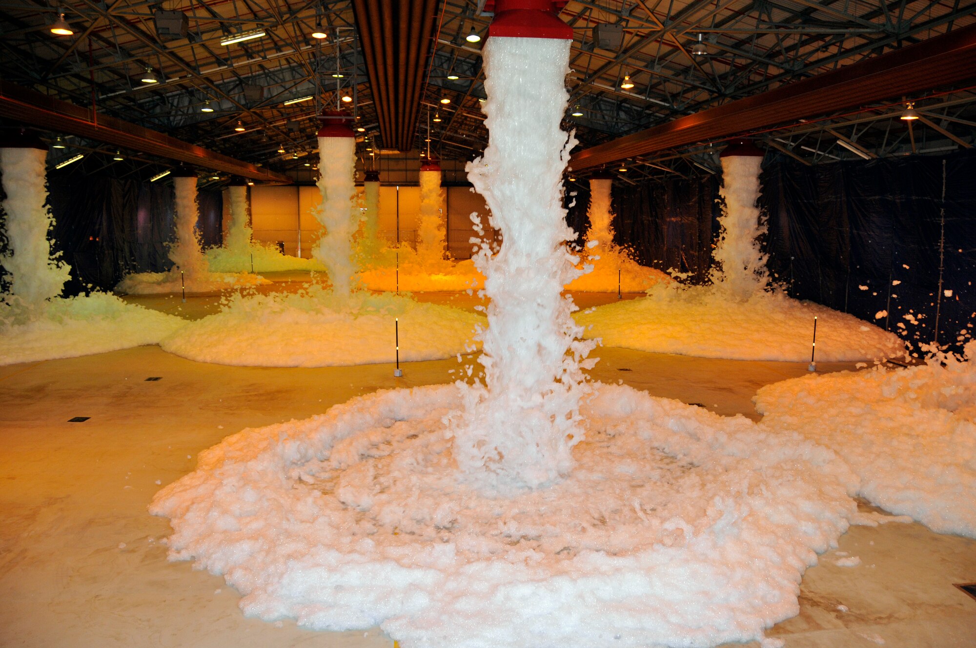 ROYAL AIR FORCE LAKENHEATH -- Firefighting foam begins to fall into hangar 7 here April 20, 2009. The hangar had to be filled with three feet of foam in under four minutes to pass the Fire Suppression System certification. (U.S. Air Force photo by Airman 1st Class Perry Aston) (Released)