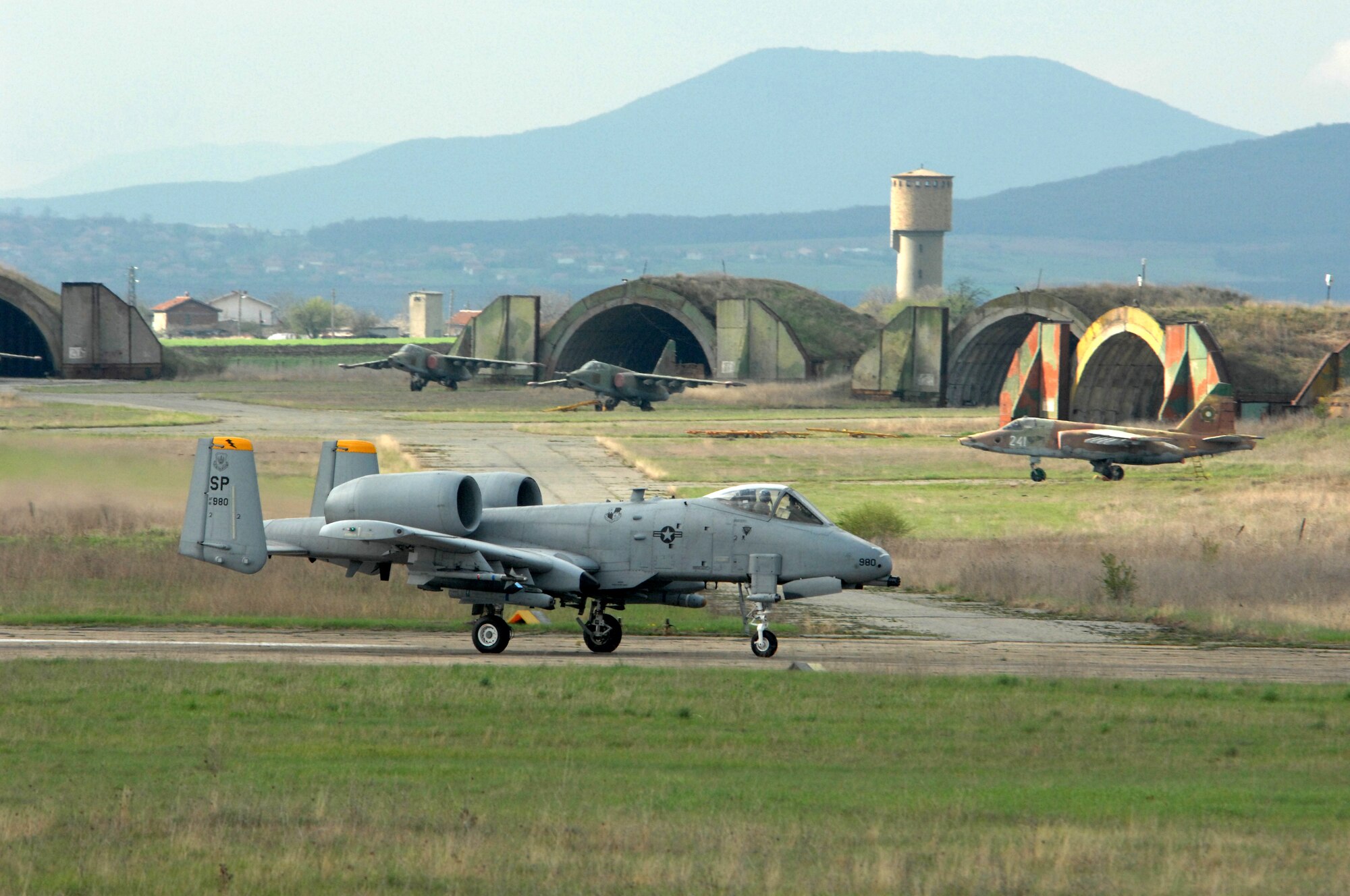 BEZMER AIR BASE, Bulgaria – An 81st Fighter Squadron A-10 “Warthog” taxis down the runway to take off on a training mission with Bulgarian SU-25s parked in the background at Bezmer Air Base, Bulgaria.  The Spangdahlem A-10s deployed here to support “Reunion April 2009” a U.S. and Bulgarian Air Forces joint training exercise. (U.S. Air Force photo by Master Sgt. Bill Gomez) 
