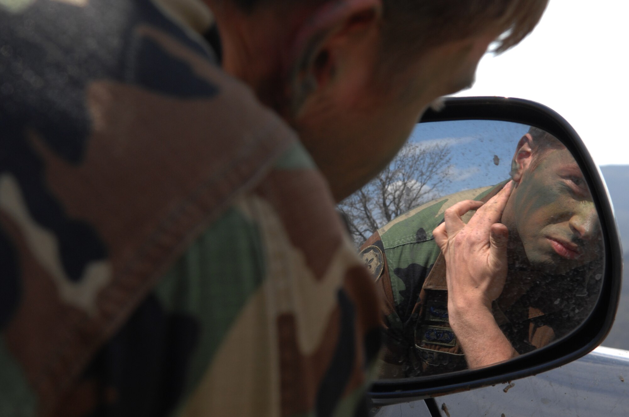 NOVO SELO, Bulgaria – Senior Airman Truman Smith, a tactical air control party radio operator, maintainer and driver, applies camouflage make-up in preparation for a search and rescue exercise April 15, 2009.  Airman Smith deployed to Bezmer Air Base, Bulgaria, from the 2nd Air Support Operations Squadron out of Vilseck, Germany, to support a joint combat search and rescue training exercise “Reunion April 2009.” (U.S. Air Force photo by Master Sgt. Bill Gomez) 