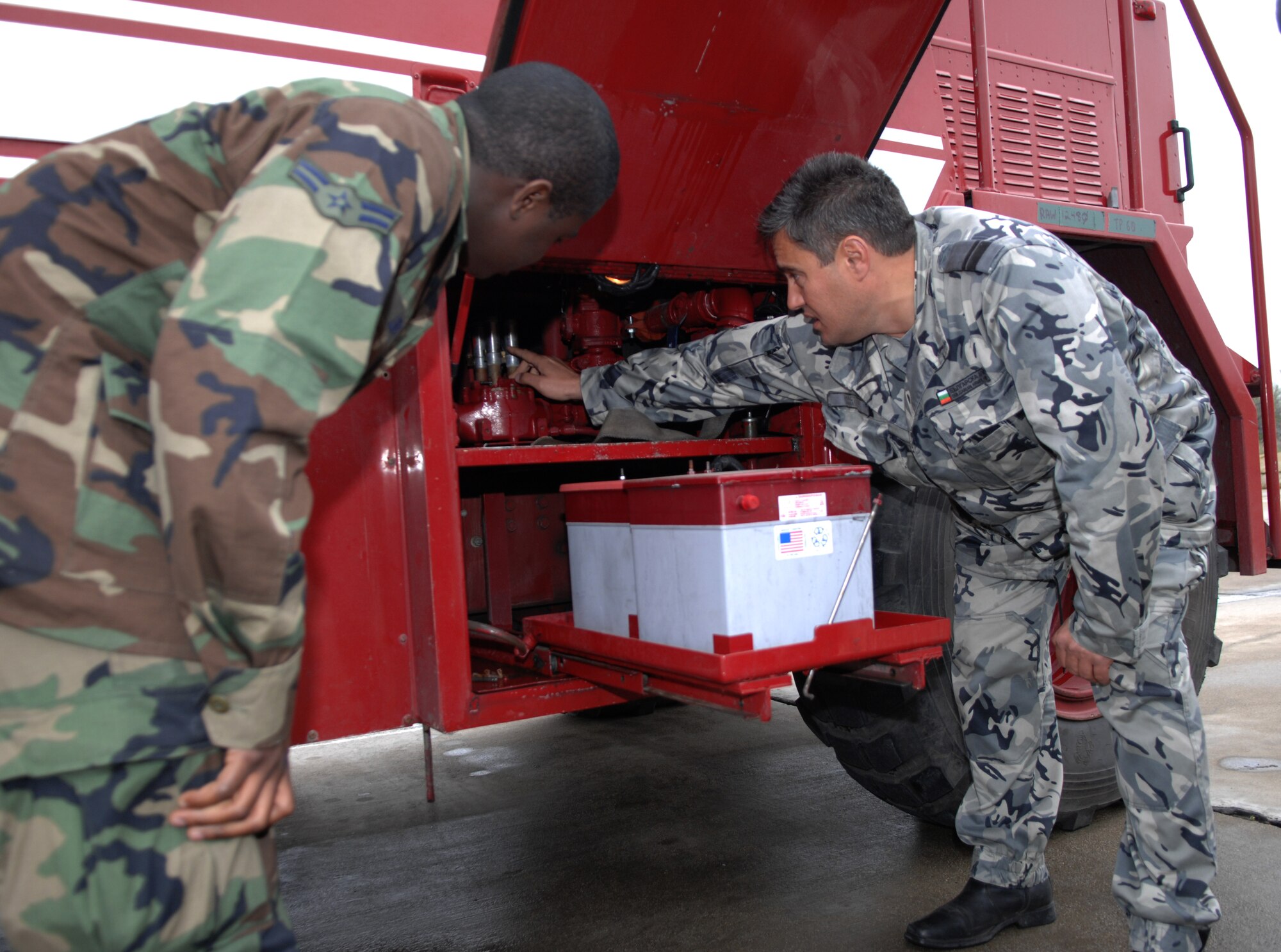 BEZMER AIR BASE, Bulgaria – Airman 1st Class Arthur J. Lewis, 52nd Civil Engineer Squadron firefighter, demonstrates the equipment on board a P-19 fire truck to a Bulgarian air force fire chief.  A six-man fire department team deployed to Bezmer Air Base, Bulgaria, to support “Reunion April 2009,” a joint training exercise. (U.S. Air Force photo by Master Sgt. Bill Gomez) 