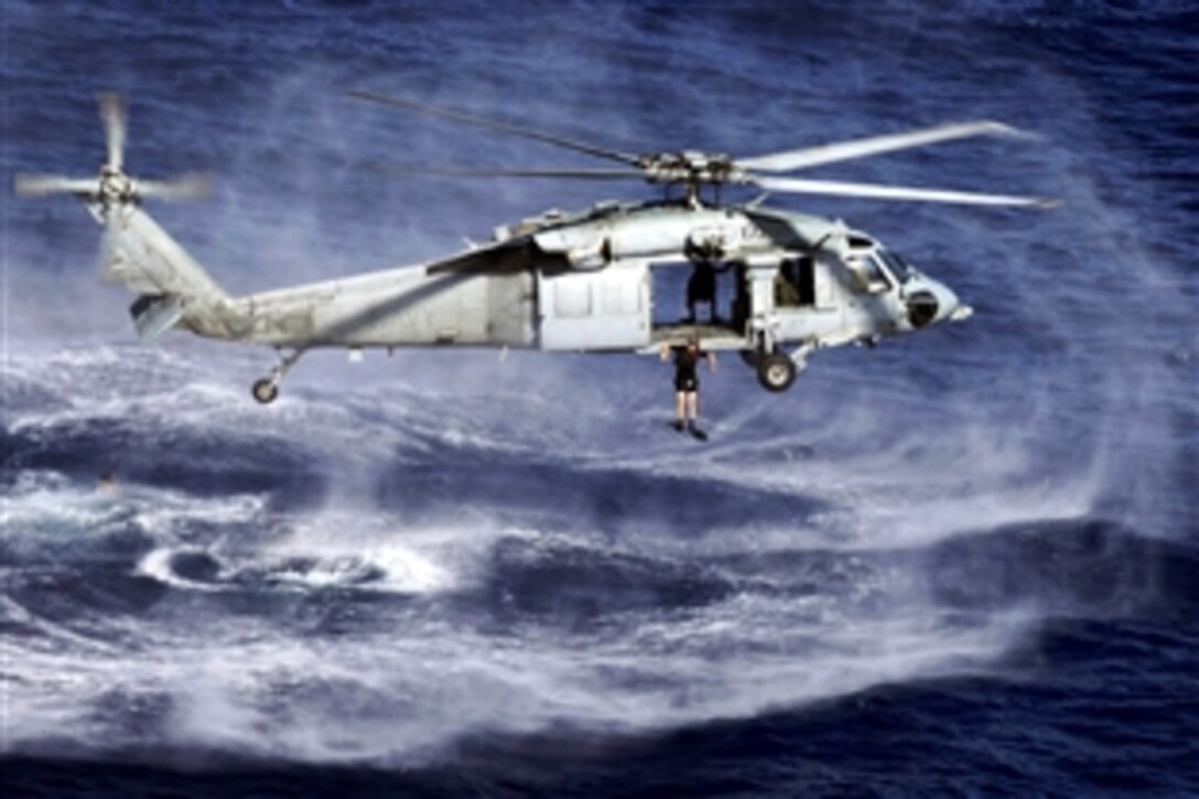 A search and rescue swimmer jumps from an MH-60S Sea Hawk helicopter from a helicopter sea combat squadron embarked aboard the amphibious assault ship USS Boxer in the Indian Ocean, April 16, 2009.