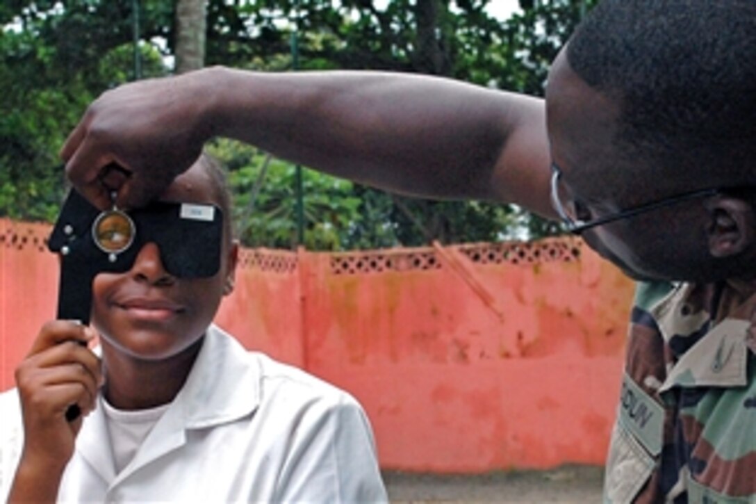 U.S. Navy Petty Officer 2nd Class Sule Abiodun tests the vision of a school girl in Libreville, Gabon, April 16, 2009. Abiodun is a member of the Africa Partnership Station Nashville, Defense Department medical team. Africa Partnership Station is a multinational initiative to work with U.S. and international partners to improve maritime safety and security in West and Central Africa. 