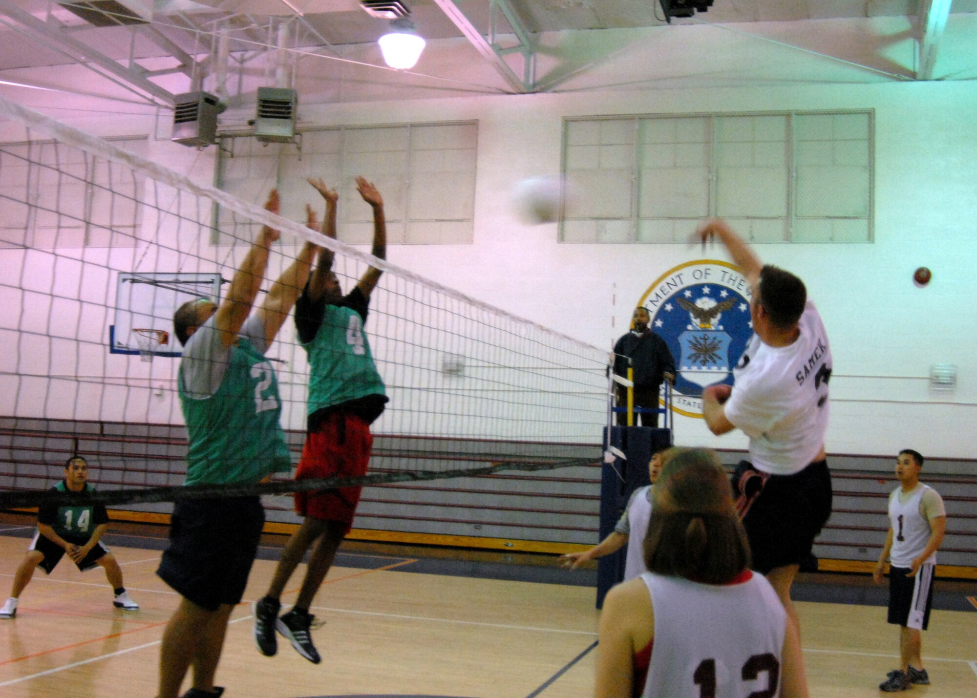 1st Lt. Joe Samek, from the 416th Flight Test Squadron team, spikes the ball past two 95th Force Support Squadron players during an intramural volleyball game at the Rosburg Fitness Center April 16. After losing the first game 21-25, the 416th FLTS defeated the 95th FSS in back-to-back games, 20-25 and 12-15. (U.S. Air Force photo/Airman 1st Class William O'Brien)