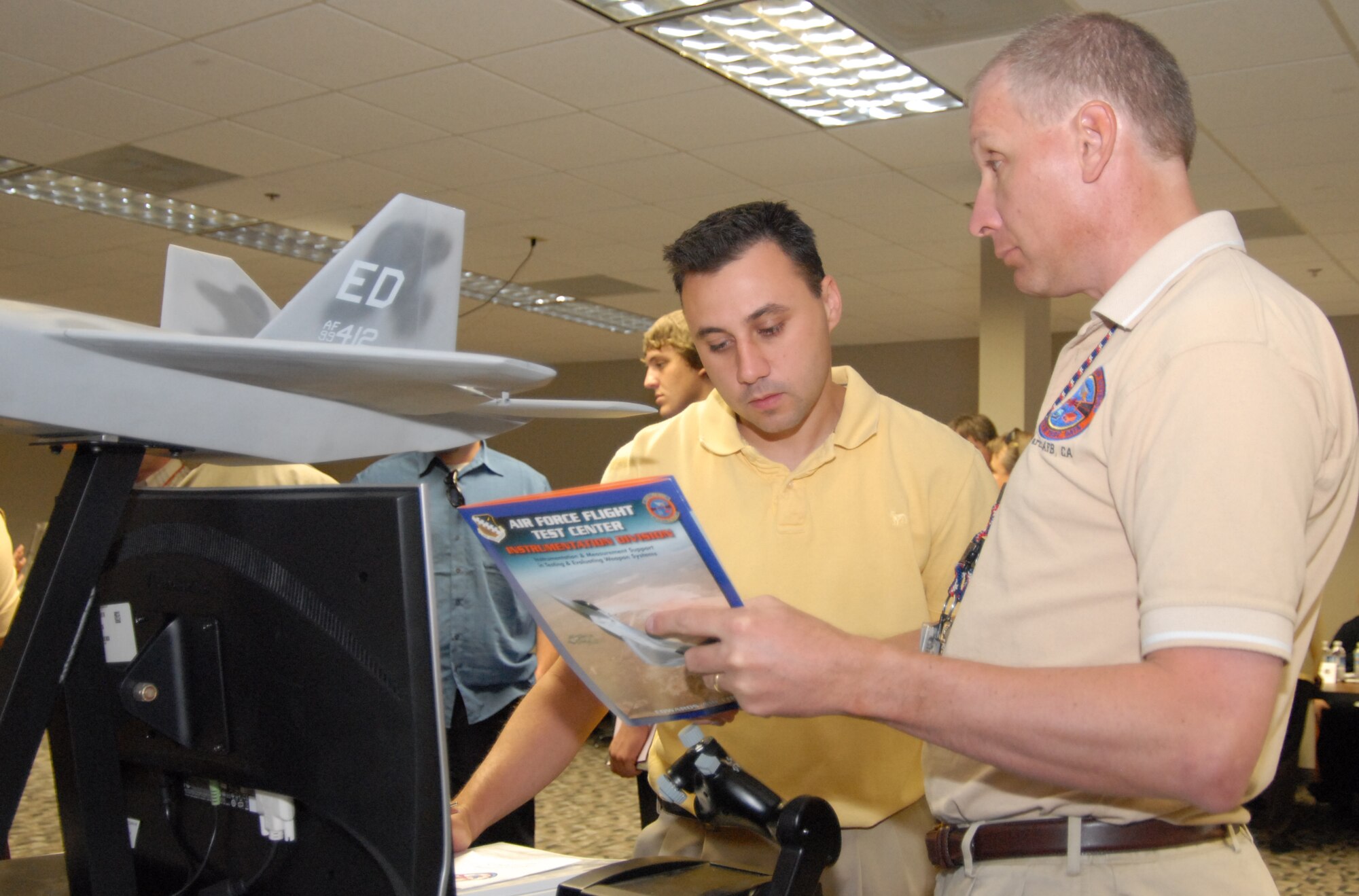 Jim Alich, 412th Test Wing modification design chief, discusses F-22 Raptor career opprutunities with David Leopold April 22. The Career Fair was held to allow personnel from across the base about other careers on base. (U.S. Air Force photo/2nd Lt. Belena S. Marquez)