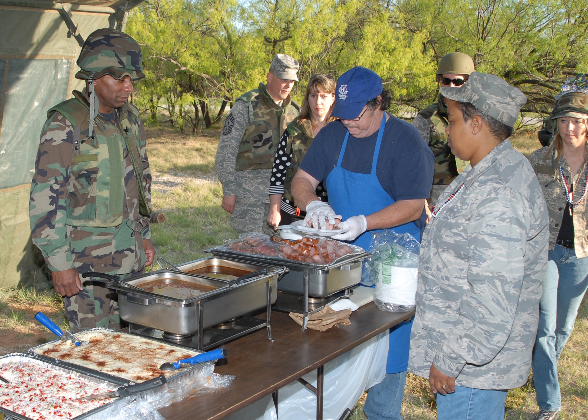 Col. Tony Pounds, 782nd Training Group commander, serves a plate of chow at the Combat Dining Out April 18 at the Medical Readiness Site. Members of the 782nd Training Group hydrate during the Combat Dinning Out. More than 100 permanent party members attended including commanders from 782nd TRG detachments at Fort Leonard Wood, Mo., Naval Construction Battalion Center Gulfport in Miss., Eglin Air Force Base, Fla., and Hill AFB, Utah. Lt. Col. Joseph Turk, deputy commander of the 782nd TRG, was the guest speaker at the event and was recognized with a plaque presented by ColonelPounds.  The purpose of the event was to build camaraderie and unit morale while fostering joint service operations within the 782nd TRG and also the Air Force. 