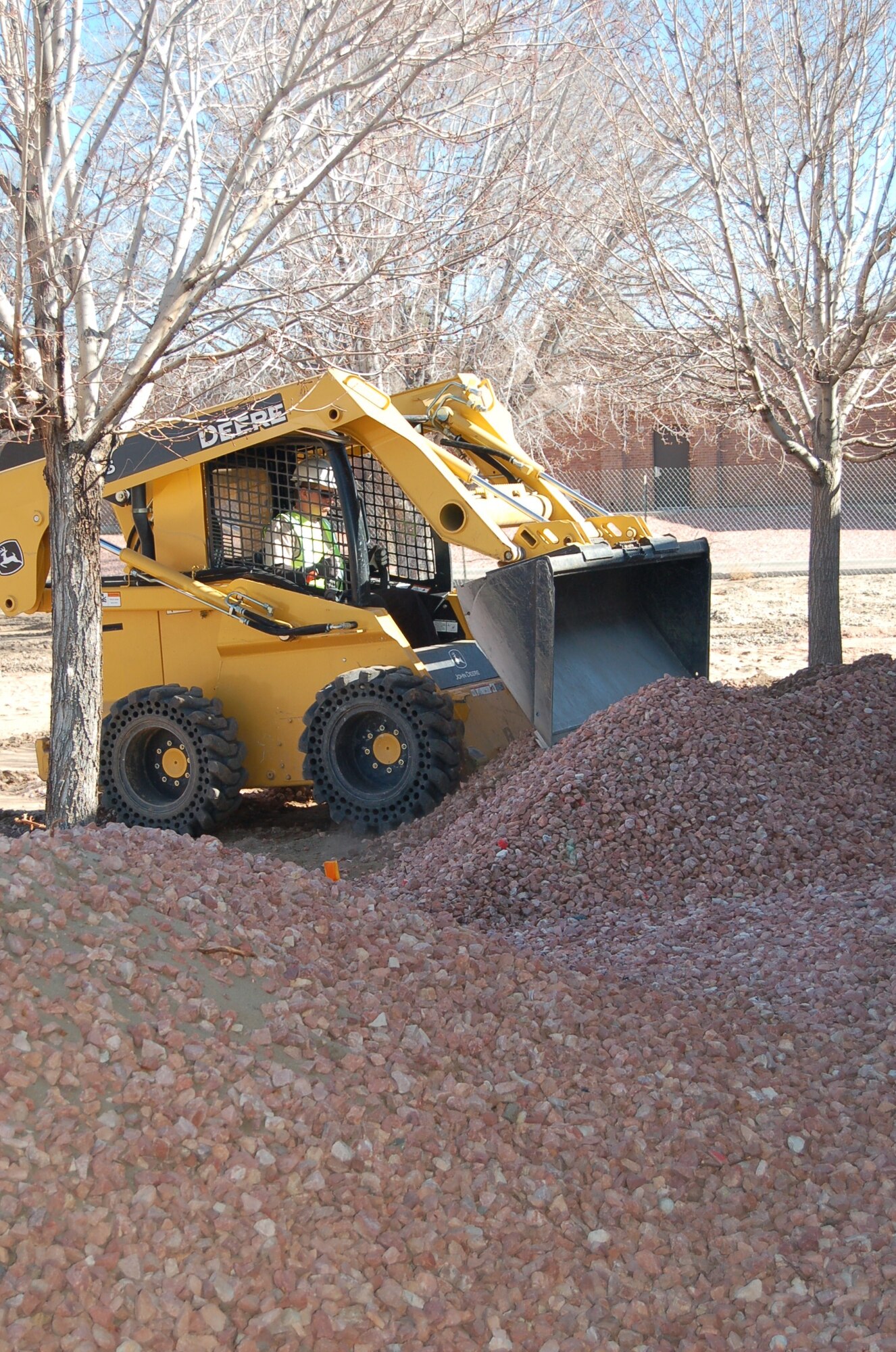 Pete Porcelli, Falcon Services operator, assists in cleaning the former site of building 880, at the corner of Ent Avenue and Suffolk Street, by hauling dirt off the locationite with a front end loader April 6. The building, along with dorm 1166, is one of two demolished at Peterson Air Force Base in 2009 toward the Air Force goal of reducing 20 percent of real property square footage and 20 percent of maintenance costs by the year 2020. The goal is part of the 2008 USAF Civil Engineer Strategic Plan. Temporary housing is scheduled to be constructed at the former site of building 880.(Air Force photo by Thea Skinner) 