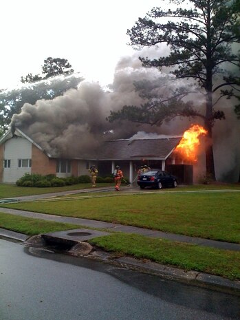 Members of the 437th Civil Engineer Squadron fire department respond to a fire April 20, at the base housing unit occupied by 1st Lt. Richard and Rachel Kerr. The Kerr's house caught fire after it was struck by lightning during a severe thunderstorm. Lieutenant Kerr is a pilot with the 16th Airlift Squadron and is currently deployed to Southwest Asia. (Courtesy Photo)