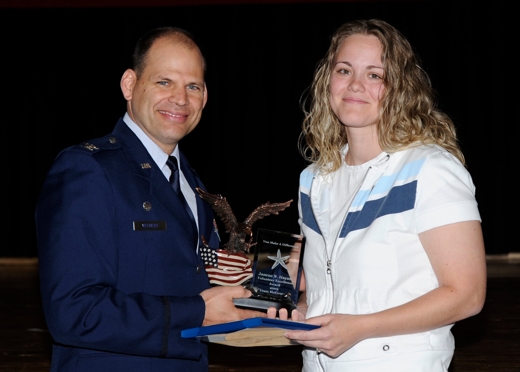 MCCONNELL AIR FORCE BASE, Kan. -- Janene Haynie is presented with her plaque and certificate of volunteer excellence from Col. James C. Vechery, 22nd Air Refueling Wing commander, during the Volunteer Appreciation Ceremony, April 16. Terri Lehman, William Reece, and Peggy Bassford also received certificates and plaques from Colonel Vechery. (Photo by Airman Justin Shelton)