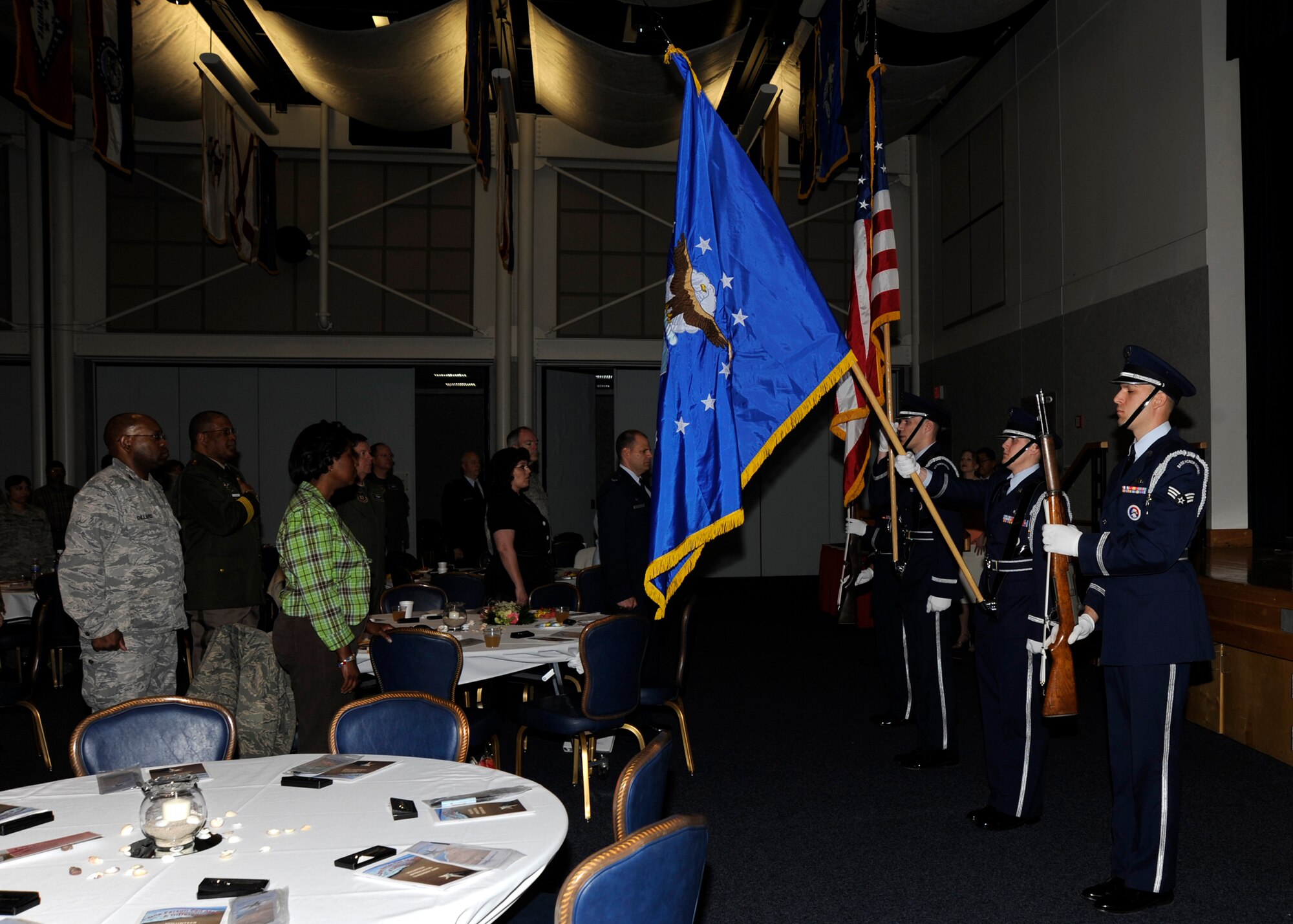MCCONNELL AIR FORCE BASE, Kan. -- The base honor guard hoists the colors as Tara Lloyd sings the national anthem, during the 18th Annual Volunteer Appreciation Ceremony at the Robert J. Dole Community Center, April 16. The Airman and Family Readiness Center orchestrated the event to recognize the work contributed by volunteers. (Photo by Airman Justin Shelton)