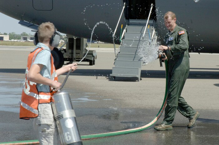 Col. John "Red" Millander and Caleb Millander prepare to spray each other April 22 on the flightline after Colonel Millander landed at Charleston AFB for his final C-17 flight. Colonel Millander took command of the 437th Airlift Wing in June 2007 and will head to the Pentagon where he will be the Chief of the Air Force's Global Mobility Division at the Pentagon. Colonel Millander is currently the 437 AW commander, and Caleb is his son. (U.S. Air Force photo/Staff Sgt. Marie Cassetty)(RELEASED)