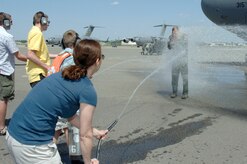 Col. John "Red" Millander gets sprayed down with water by his family April 22 on the flightline after landing at Charleston AFB for his final C-17 flight. Colonel Millander took command of the wing in June 2007 and will leave Charleston AFB to become the Chief of the Air Force's Global Mobility Division at the Pentagon. Colonel Millander is currently the 437th Airlift Wing commander. (U.S. Air Force photo/Staff Sgt. Marie Cassetty)(RELEASED)
