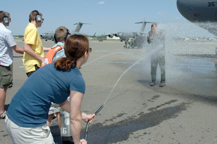 Col. John "Red" Millander gets sprayed down with water by his family April 22 on the flightline after landing at Charleston AFB for his final C-17 flight. Colonel Millander took command of the wing in June 2007 and will leave Charleston AFB to become the Chief of the Air Force's Global Mobility Division at the Pentagon. Colonel Millander is currently the 437th Airlift Wing commander. (U.S. Air Force photo/Staff Sgt. Marie Cassetty)(RELEASED)