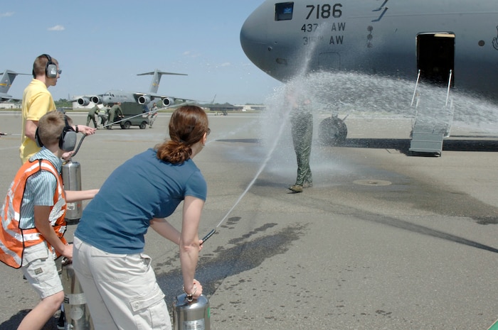 Col. John "Red" Millander gets hosed down with water by his family April 22 on the flightline after landing at Charleston AFB for his final C-17 flight. Colonel Millander took command of the wing in June 2007 and will leave Charleston AFB to become the Chief of the Air Force's Global Mobility Division at the Pentagon. Colonel Millander is currently the 437th Airlift Wing commander. (U.S. Air Force photo/Staff Sgt. Marie Cassetty)(RELEASED)