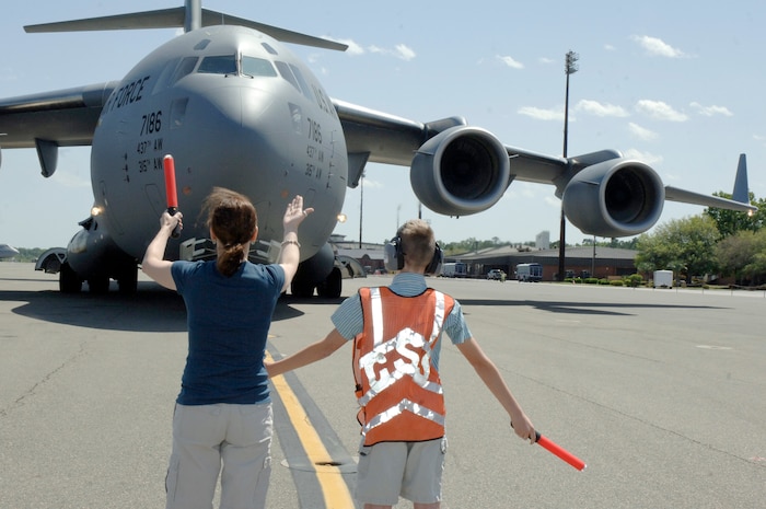 Deb and Caleb Millander marshal in Col. John "Red" Millander April 22 on the flightline after landing at Charleston AFB for his final C-17 flight. Colonel Millander took command of the wing in June 2007 and will head to the Pentagon to become the Chief of the Air Force's Global Mobility Division. Colonel Millander is currently the 437th Airlift Wing commander, Deb is his wife and Caleb is his son.  (U.S. Air Force photo/Staff Sgt. Marie Cassetty)(RELEASED)