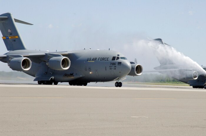 Col. John "Red" Millander taxis through spray from a firetruck April 22 on the flightline after landing at Charleston AFB for his final C-17 flight. Colonel Millander took command of the wing in June 2007 and will leave Charleston AFB to become the Chief of the Air Force's Global Mobility Division at the Pentagon. Colonel Millander is currently the 437th Airlift Wing commander. (U.S. Air Force photo/Staff Sgt. Marie Cassetty)(RELEASED)