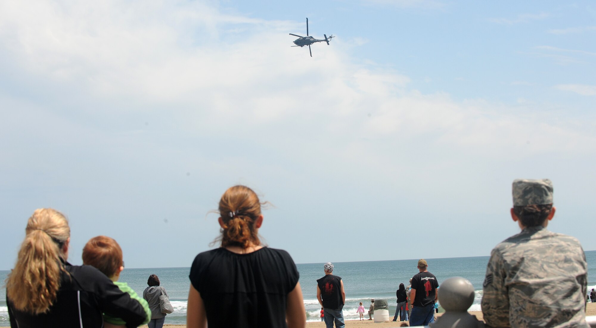LANGLEY AIR FORCE BASE, Va.  --  Bystanders watch a HH-60G Pave Hawk helicopter during the Joint Air Power Demonstration at the Virginia Beach boardwalk April 22. The demonstration showcased the critical role air power plays in the joint fight. This is one of many events going on in the Hampton Roads area as the Air Force members say “thank you” to the community during Hampton Roads Air Force Week. (U.S. Air Force photo/Airman 1st Class Gul Crockett) 
