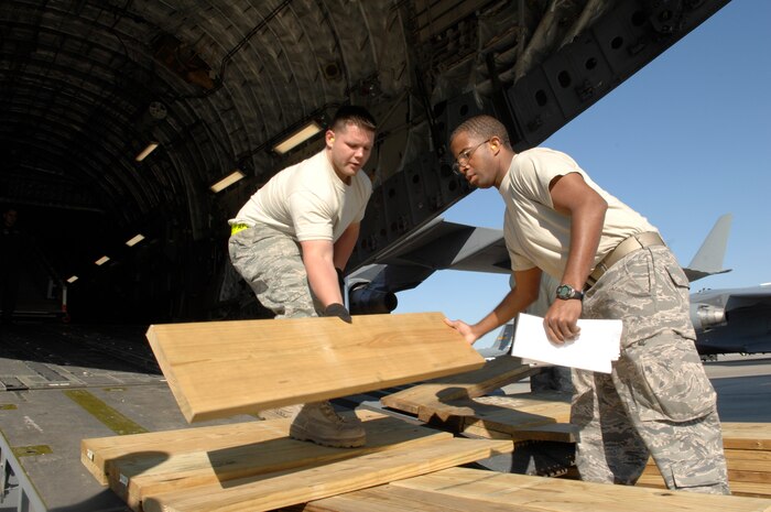 Senior Airmen Joshua Humble, left, and Raymond Banks build a shoring kit at Charleston AFB, April 22. The shoring kit was used to offload a staircase truck from a McChord-based C-17. Airmen Humble and Banks are air transportation journeymen with the 437th Aerial Port Squadron. (U.S. Air Force photo/James Bowman)