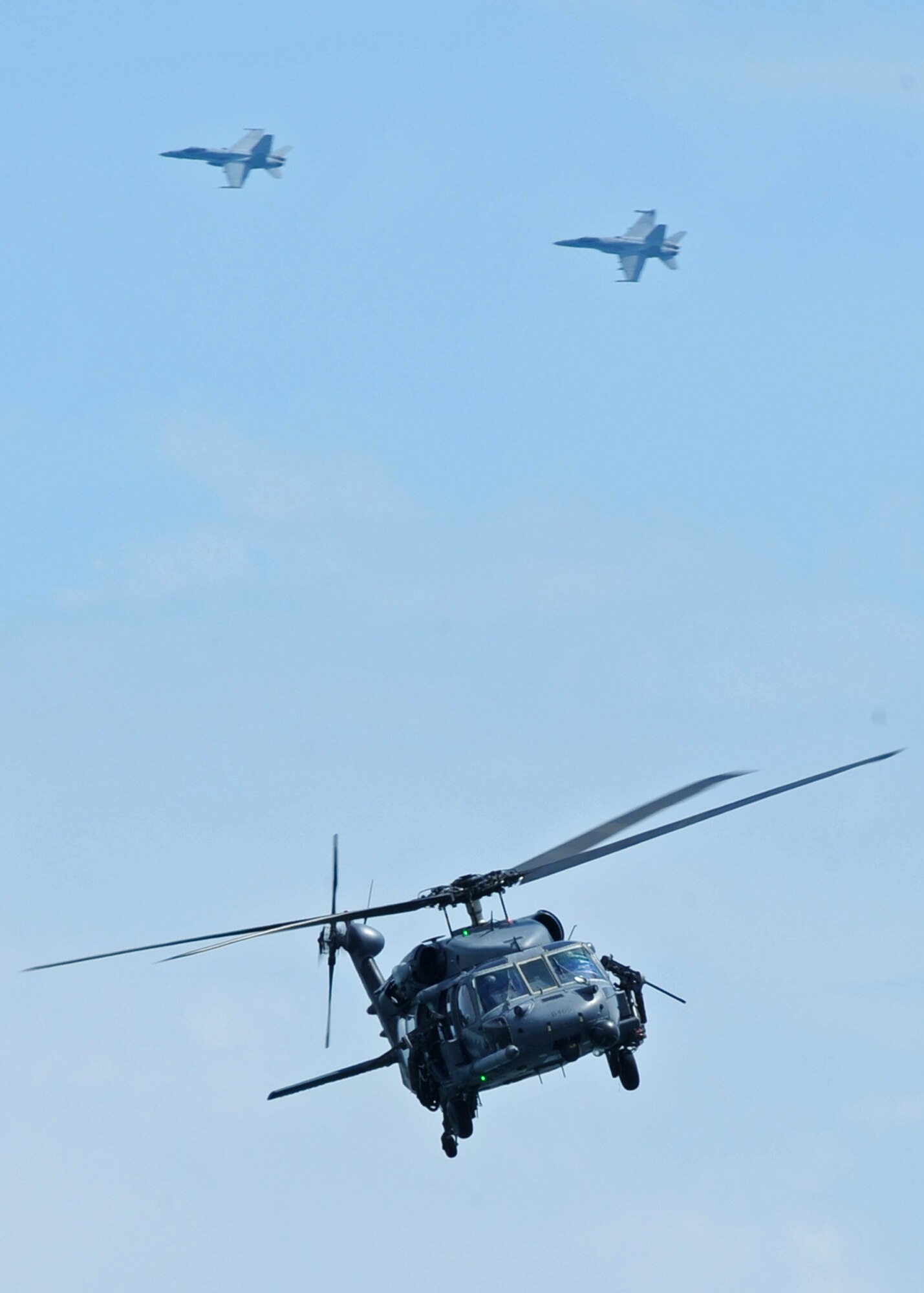 LANGLEY AIR FORCE BASE, Va. -- The 41st Rescue Squadron HH-60G Pave Hawk helicopter, Moody Air Force Base, Ga., receives air cover from the 34 Strike Fighter Squadron F/A-18 Hornets, Oceana Naval Station, Va., during the Joint Air Power Demonstration at the Virginia Beach boardwalk April 22. The demonstration showcased the critical role air power plays in the joint fight. This is one of many events going on in Hampton Roads Air Force Week.   (U.S. Air Force photo/Airman 1st Class Jonathan Koob)   