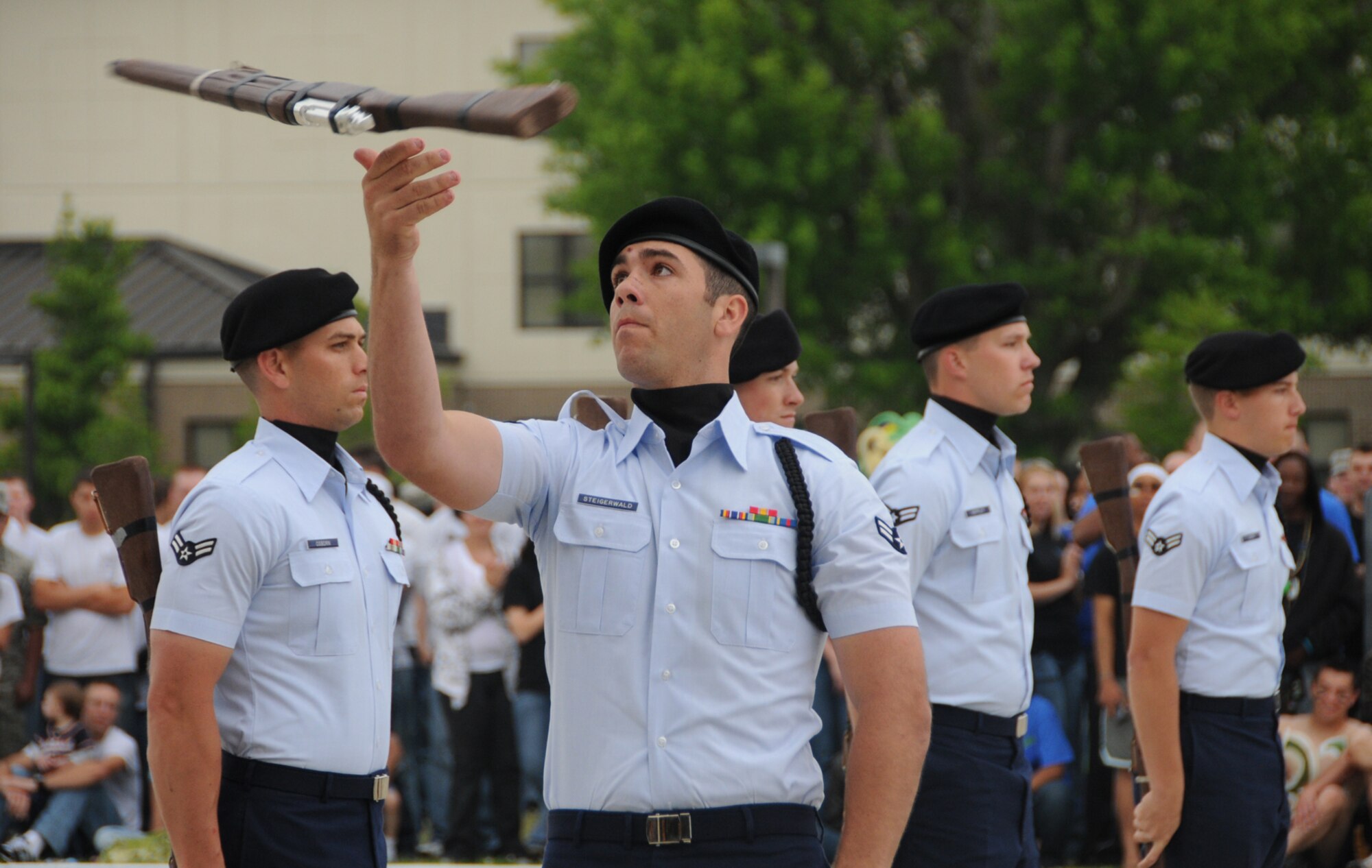 Airman 1st Class Jonathan Stiegerwald, drill master for the 335th Training Squadron drill team, twirls a rifle as, from left, Airmen 1st Class Janee Osborn, Stephen Trit-ten, Theodore Keppley and Zachary Sura stand at attention during the Bulls’ freestyle performance at Friday’s drill down.  The Bulls placed first in freestyle and regulation drill and second in open ranks to win the overall title.  (U.S. Air Force photo by Kemberly Groue)