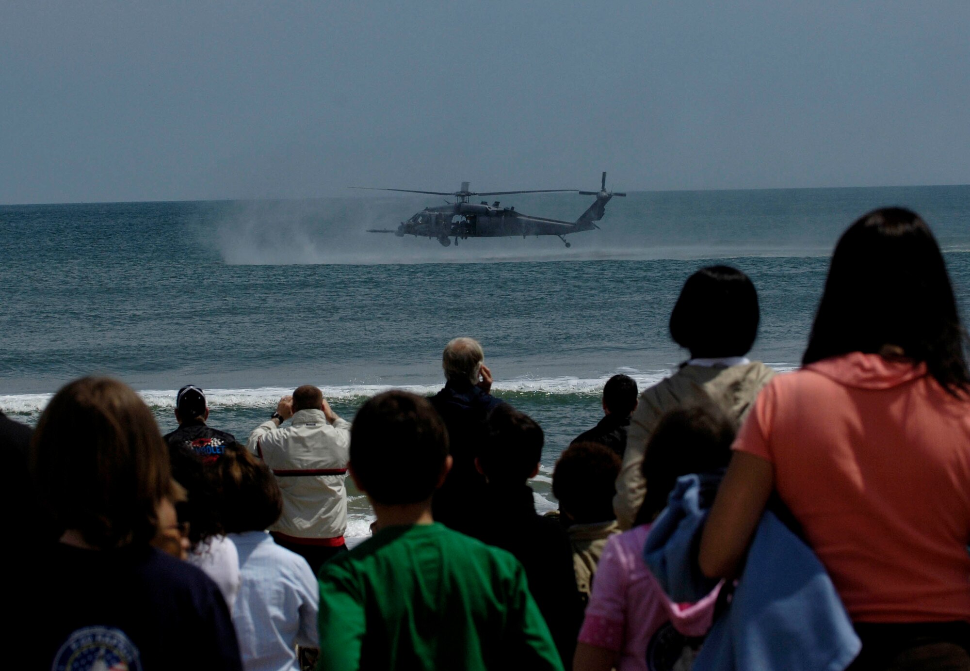 LANGLEY AIR FORCE BASE, Va. -- Spectators watch the 41st Rescue Squadron HH-60 Pave Hawk helicopter, Moody Air Force Base, Ga., extract 38th Rescue Squadron pararescuemen, Moody AFB, during the Joint Air Power Demonstration at the Virginia Beach boardwalk April 22. The demonstration showcased the critical role air power plays in the joint fight. This is one of many events going on in the Hampton Roads area as the Air Force members say "thank you" to the community during Hampton Roads Air Force Week. (U.S. Air Force photo/Airman Rebecca Montez)