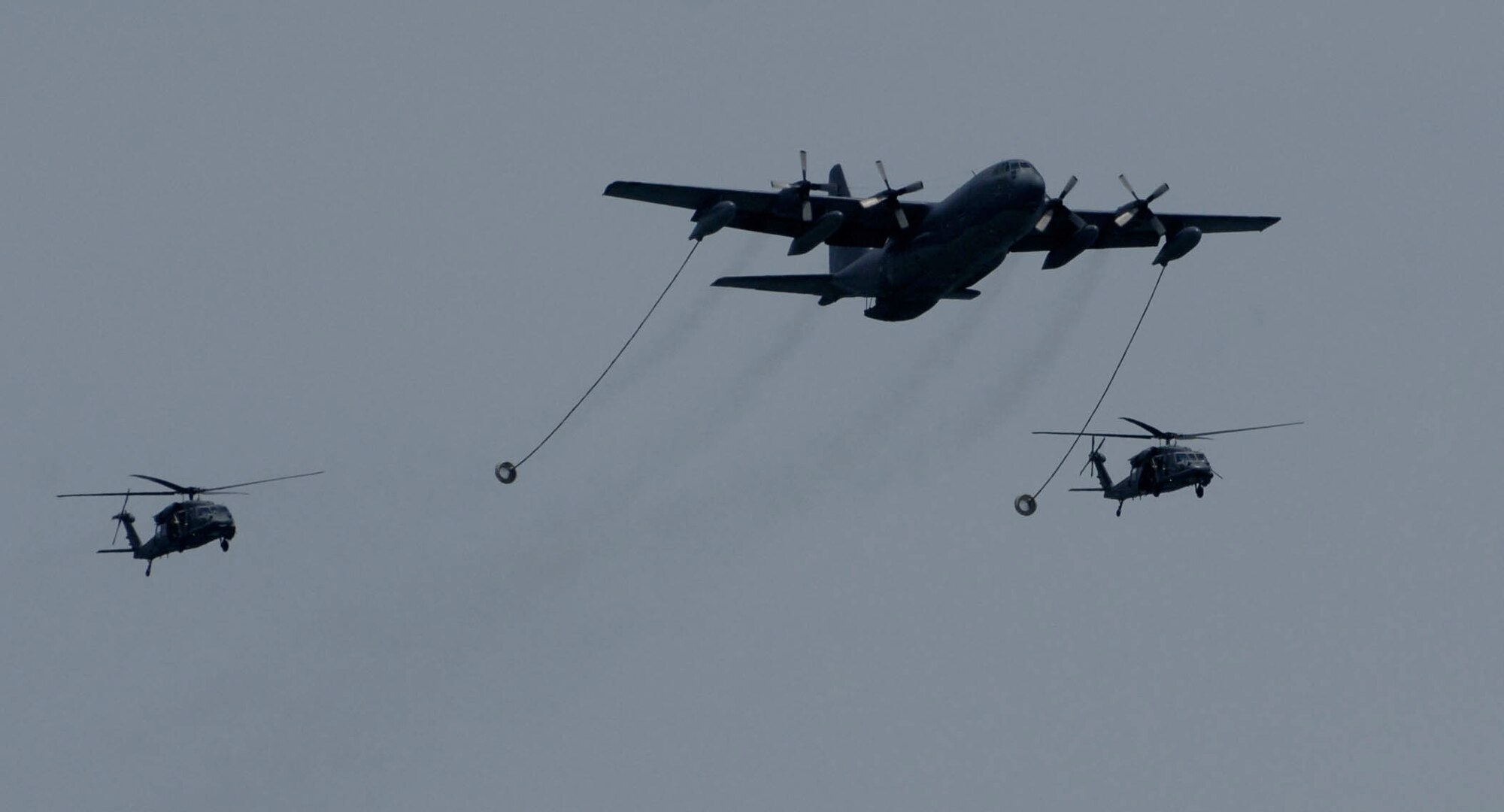 LANGLEY AIR FORCE BASE, Va. -- The 71st Rescue Squadron HC-130, refuels the 41st Rescue Squadron HH-60G Pave Hawk helicopters, during the Joint Air Power Demonstration at Virginia Beach boardwalk April 22.  The demonstration showcased the critical role air power plays in the joint fight. This is one of many events going on in the Hampton Roads area as the Air Force members say "thank you" to the community during Hampton Roads Air Force Week.  (U.S. Air Force photo/Airman Rebecca Montez)