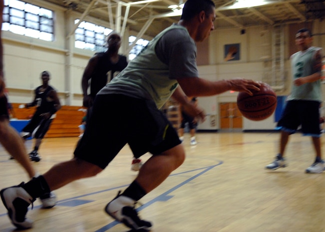 The Coast Guard's Larry Lopez dribbles the ball during the intramural basketball playoff game against the 437th Security Forces Squadron at the Fitness and Sports Center here April 20. SFS defeated CG 51-46. The playoffs began April 20 ended April 23. Lopez is with the Maritime Law Enforcement Academy. (U.S. Air Force photo/Senior Airman Katie Gieratz)(RELEASED)
