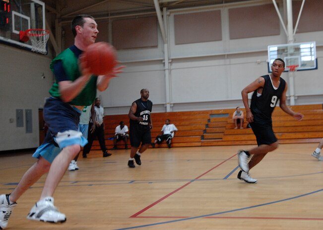 Jeremy Higgings looks to pass the ball down the court during an intramural basketball playoff game at the Fitness and Sports Center here April 20. The 437th Security Forces Squadron defeated the Coast Guard 51-46. The playoffs began April 20 and finished April 23. Higgins is with the Maritime Law Enforcement Academy and is a member of the CG. (U.S. Air Force photo/Senior Airman Katie Gieratz)(RELEASED)