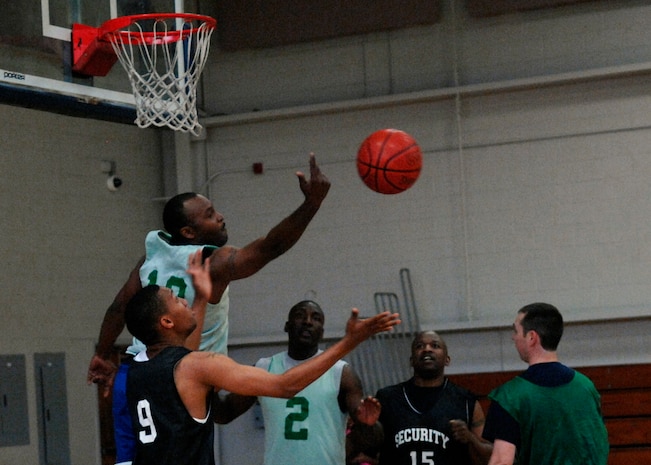 Dewayne Stokes attempts to gain possession of the ball during an intramural basketball playoff game at the Fitness and Sports Center here April 20. The 437th Security Forces Squadron defeated the Coast Guard 51-46. There are currently 14 teams in the playoffs. Stokes is with the Maritime Law Enforcement Academy and is a member of the CG. (U.S. Air Force photo/Senior Airman Katie Gieratz)(REALEASED)