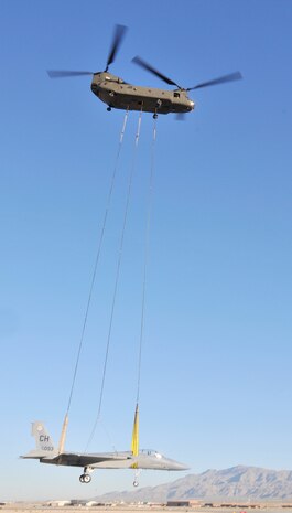 A Nevada National Guard CH-47 Chinook lifts an F-15A Eagle from Nellis Air Force Base, Nev., to its new home at nearby Creech AFB, April 22. The Eagle, a non-flying maintenance trainer, made the 45-minute journey at a sedate 70 mph to become a Creech fire department pilot rescue trainer.  (U.S. Air Force photo by Gary Emery)
