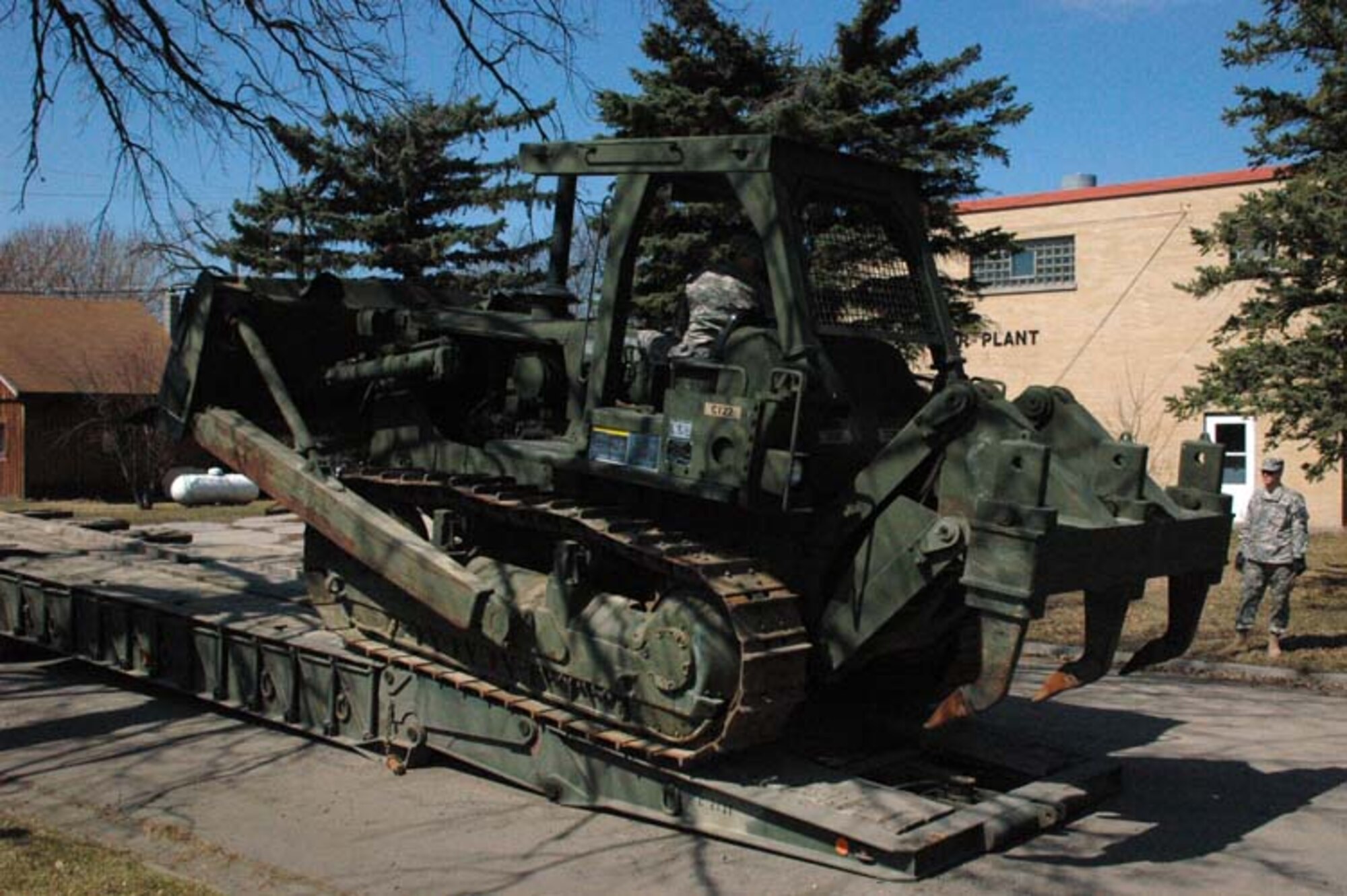 Sgt. Tobias J. Mathern, a Soldier with the 815th Engineer Company, carefully drives a D-7 dozer off of a trailer. The 815th has been assisting a civilian contractor since April 17 to raise the city's levee.  
