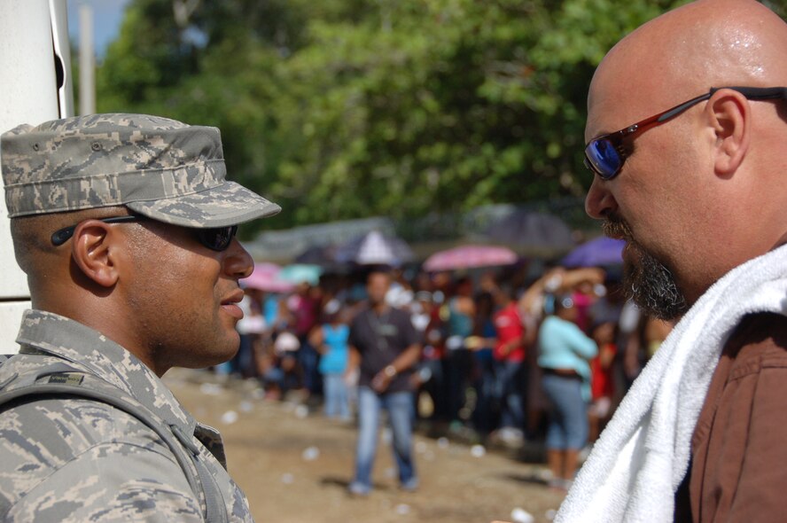 John Henry the mission planner of the largest Maxwell Air Force
Base-planned U.S. Air Force Medical Readiness Training Exercise (MEDRETE) to
date, from the 42nd Medical Group, consults Tech. Sgt. Marcus Jackson,
Security Forces day shift flight chief, 42nd Security Forces Squadron,
Maxwell Air Force Base, Ala. at the start of the day outside of the gate at a primary
school in Hostos, Dom. Rep., as patients line up in the background April 20.
A group of 45 medics, translators, security and support personnel derived
from the U.S. Air Force, Army and Marines provided dental, dermatologic,
general medicine, optometric, pediatric, pharmacy and public health
services. The medics treated 760 patients on the first day as part of the
10-day U.S. SOUTHCOM sponsored Beyond the Horizon 2009 - Caribbean. A
MEDRETE is a U. S. Southern command-sponsored exercise designed to provide
humanitarian assistance and free medical care to the people of the host
nation, while providing an unparalleled training opportunity for U.S. and
host nation forces. SOUTHCOM sponsors approximately 70 MEDRETEs per year.
(U.S. Air Force Photo by Capt. Ben Sakrisson)

