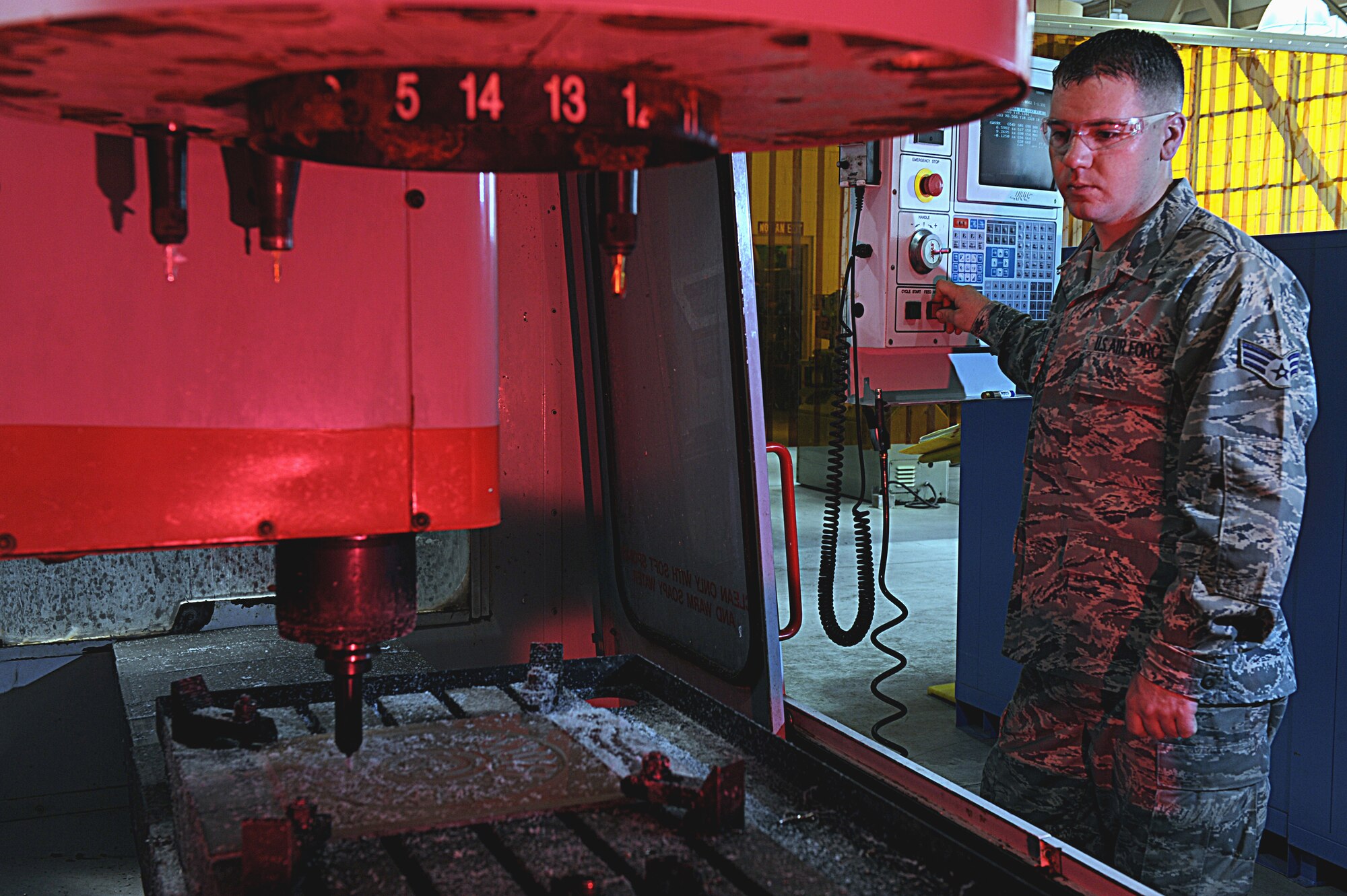 Senior Airman Chad Mattingly programs a metal template into the computer numeric control April 16 at Nellis Air Force Base, Nev. The 57th CMS uses machines like the CNC to make structural repairs to components for various aircraft.(U.S. Air Force photo/Senior Airman Nadine Y. Barclay)