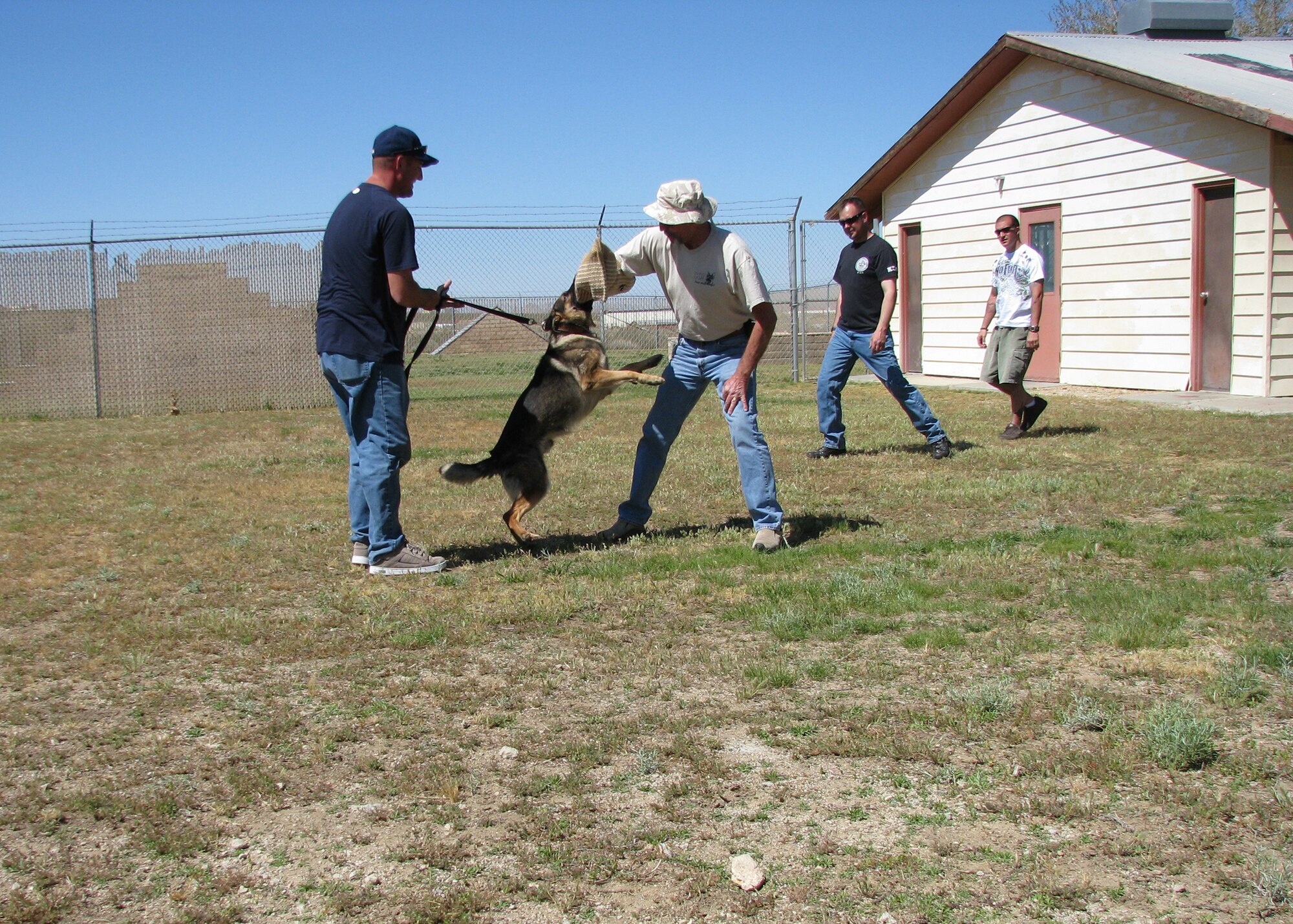 Staff Sgt. Eric Magnuson, 95th Security Forces Squadron K-9 handler, handles Military Working Dog Nix as they display the capabilities of today's military working dog to group of Vietnam-era dog handlers at the 95th SFS working dog area April 19. "Feed the Dawgs," is a group of Vietnam era dog handlers who visit K-9 handlers and provide meals for the handlers and their families. (U.S. Air Force photo/Lisa Camplin)