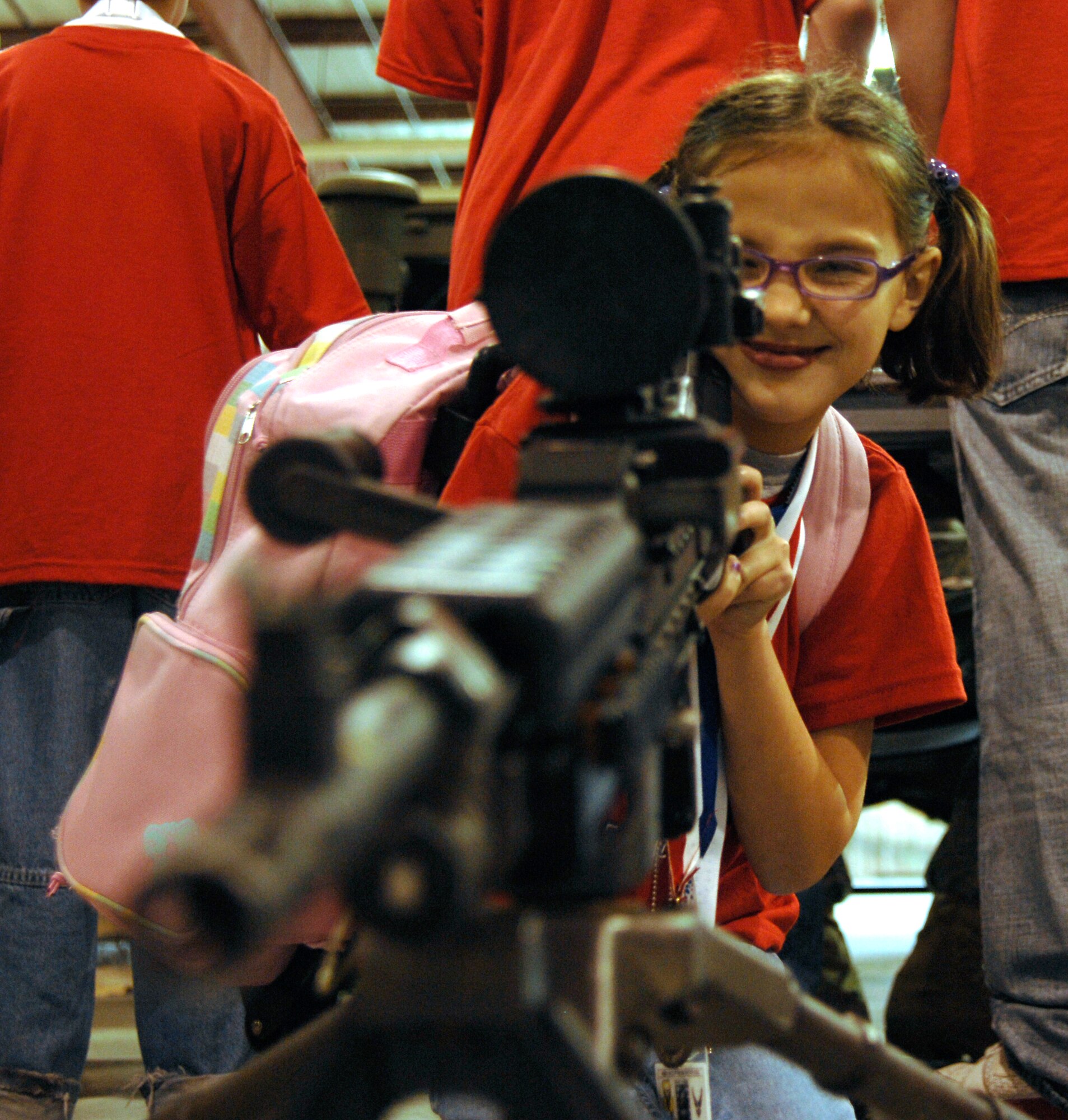 WHITEMAN AIR FORCE BASE, Mo. - "Airman" Sydney Gracey takes aim with a M240B machine gun April 18 during Operation Spirit. The "Airmen" participated in a mock deployment to Kabul, Afghanistan. Operation Spirit is a simulated deployment line for school-aged kids that allows children to experience what their military parents go through during a deployment. The "Airmen" were accompanied by their parents and received goodies form several base agencies. (U.S. Air Force photo/Staff Sgt. Jason Barebo)