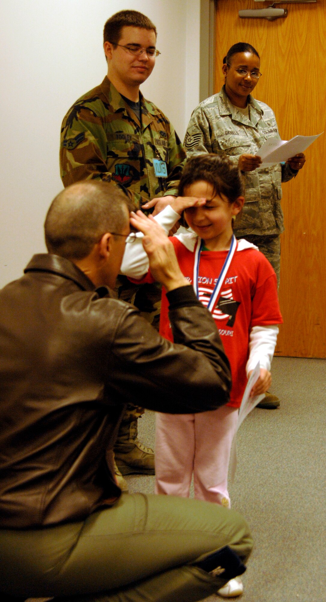 WHITEMAN AIR FORCE BASE, Mo. - "Airman" Melody Mertes salutes Col. Thomas Bussiere, 509th Operations Group commander, April 18 during an awards ceremony at Operation Spirit. Operation Spirit is a simulated deployment line for school-aged kids that allows children to experience what their military parents go through during a deployment. The "Airmen" were accompanied by their parents and received goodies form several base agencies. (U.S. Air Force photo/Staff Sgt. Jason Barebo)