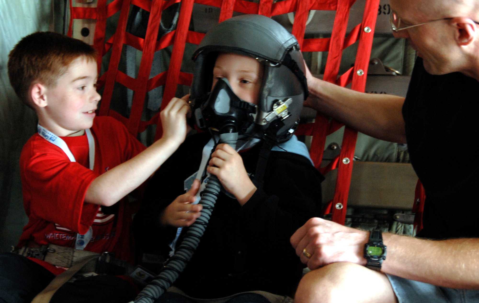 WHITEMAN AIR FORCE BASE, Mo. - "Airman" Andrew Cizek tries on a pilot’s helmet while on board a C-130 April 18 during Operation Spirit. Young "Airmen" were able to experience several aspects of deploying to help them better understand what their parents go through during a real-world deployment. Operation Spirit is a simulated deployment line for school-aged kids that allows children to experience what their military parents go through during a deployment. The "Airmen" were accompanied by their parents and received goodies form several base agencies. (U.S. Air Force photo/Staff Sgt. Jason Barebo)