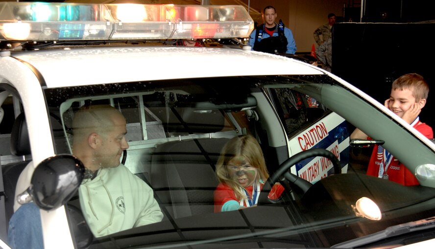 WHITEMAN AIR FORCE BASE, Mo. - A young "Airmen" tests the lights and sirens of a 509th Security Forces Squadron squad car April 18 during Operation Spirit. Operation Spirit is a simulated deployment line for school-aged kids that allows children to experience what their military parents go through during a deployment. The "Airmen" were accompanied by their parents and received goodies form several base agencies. (U.S. Air Force photo/Staff Sgt. Jason Barebo)