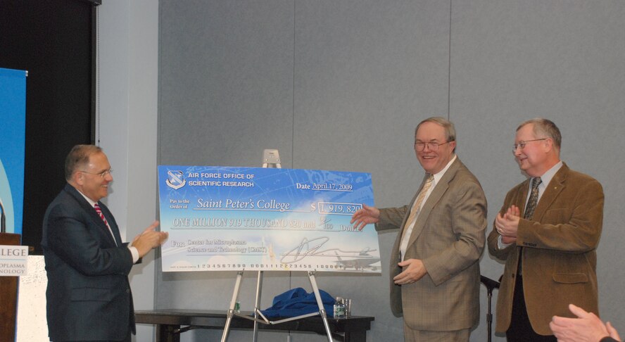 (L-R) St. Peter's College President Eugene J. Cornacchia, Ph.D. accepts a large novelty check from AFOSR Director Dr. Brendan Godfrey and AFOSR program manager, Dr. Robert Barker. The money will help fund the formal establishment of the college's Center for Microplasma Science and Technology. (Credit: St. Peter's College, Jersey City, N.J.)