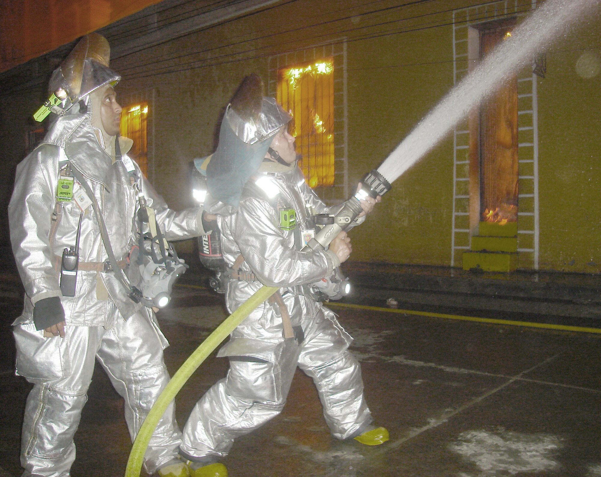 Joint Task Force-Bravo firefighters Staff Sgt. Peter Franko (left) and Senior Airman Daniel Meginness work to supress a fire April 15 in Comayagua, Honduras. Seven JTF-B firefighters responded to assist the Comayagua Fire Department with the blaze that erupted near the central plaza around 8 p.m.  (U.S. Air Force photo)